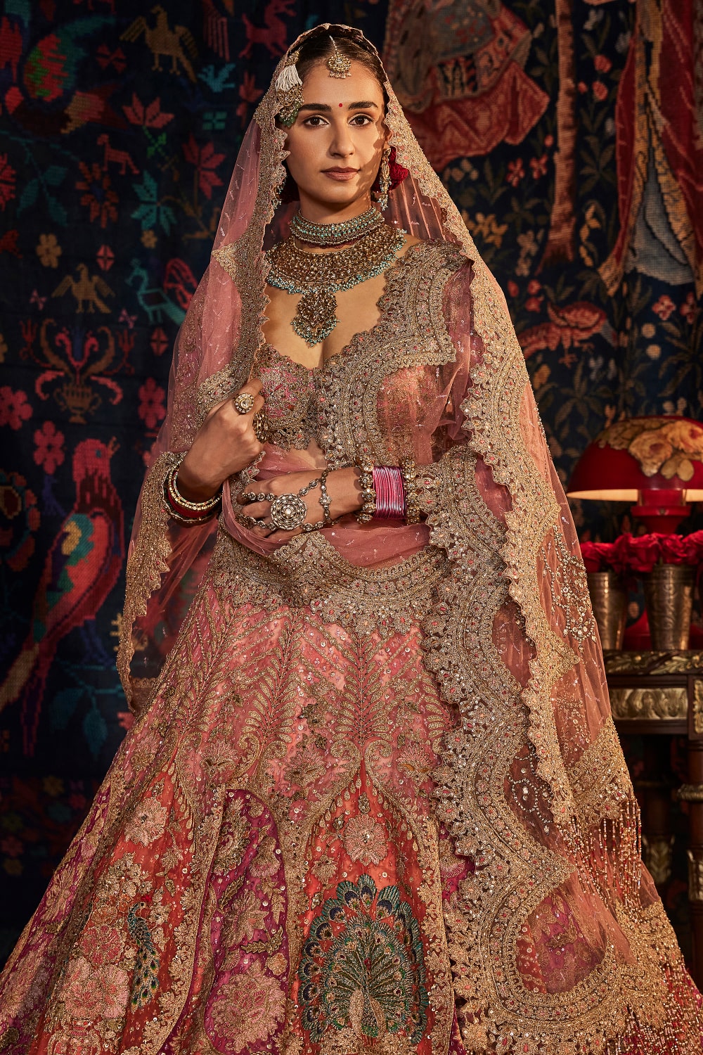 Rimple and Harpreet Narula - Mokshi's bespoke gold and ashes of rose  silk-tulle lehenga features Arabesque cartouches and floral motifs derived  from vintage textiles and Mughal inlay work, layered over a ground